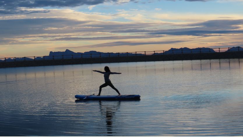 Une femme pratiquant du yoga sur paddle