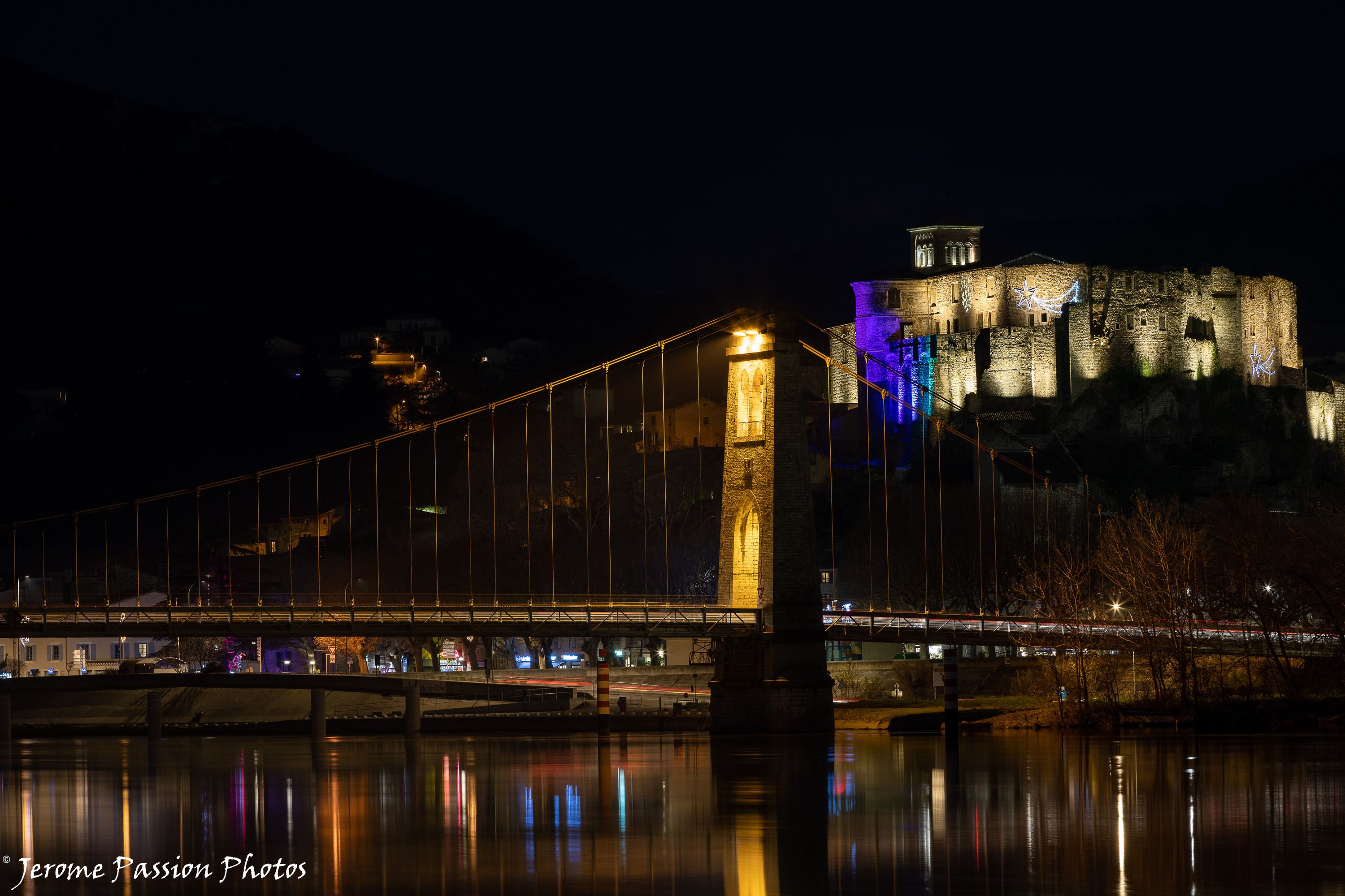 Vue sur le château de nuit depuis les berges en face de La Voulte sur Rhône