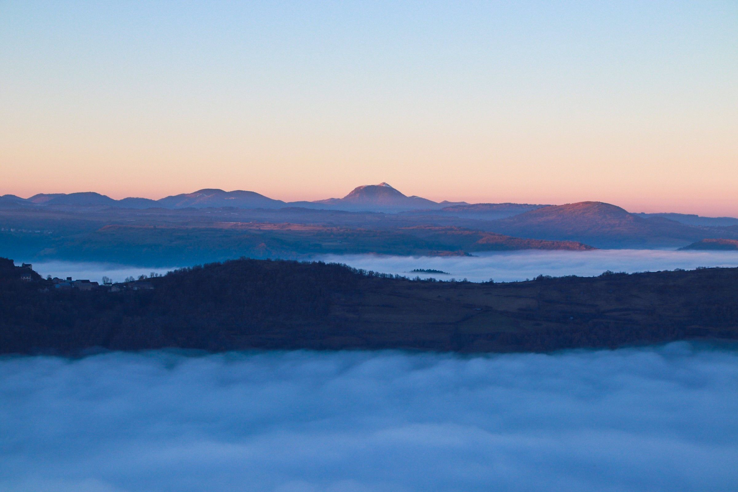 Vue sur la chaîne des Puys avec mer de nuages au coucher du soleil
