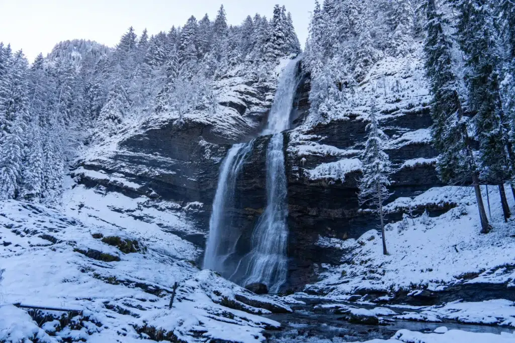 cascade rocheuse dans une montagne enneigée