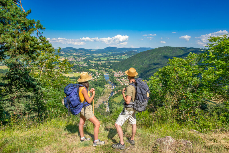 Deux randonneurs sur le chemin de Compostelle de Cluny au Puy-en-Velay, panorama sur la Loire et la plaine de l'Emblavès
