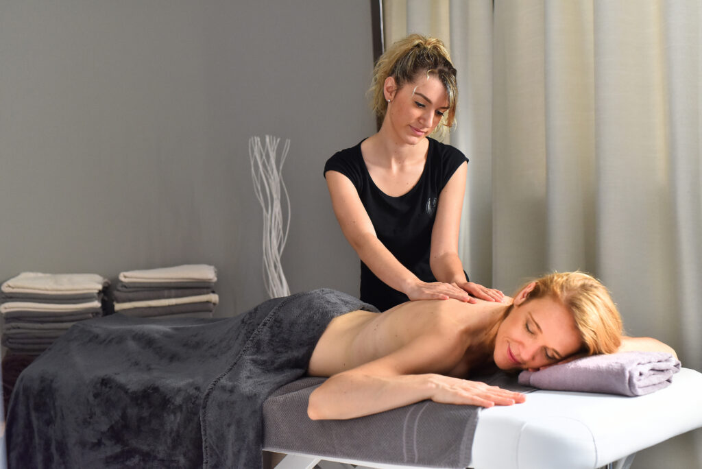 Femme allongée recevant un massage d'une esthéticienne aux thermes d'Allevard