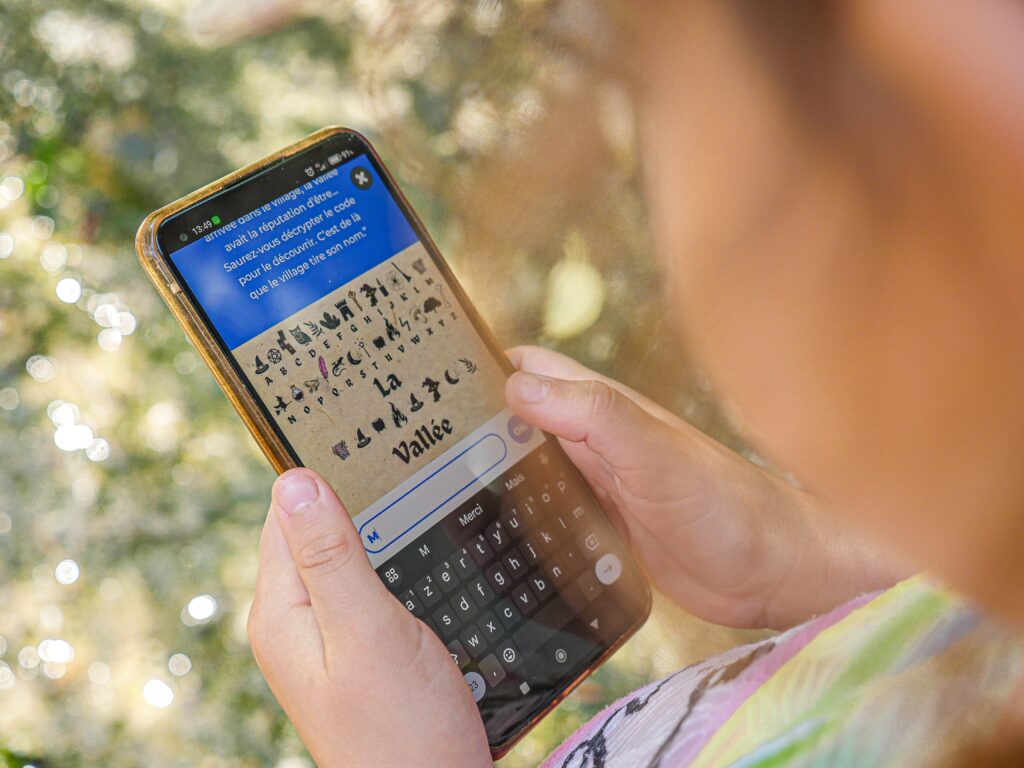Enfant qui résout une énigme sur l'application Baludik sur son téléphone