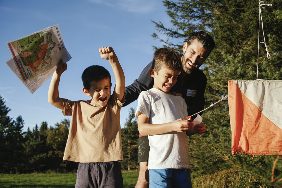 Enfants réalisant un parcours d'orientation avec leur père