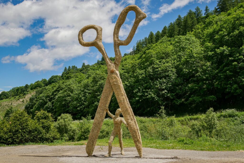 Sculpture gigantesque réalisée en paille et foin représentant une paire de ciseaux