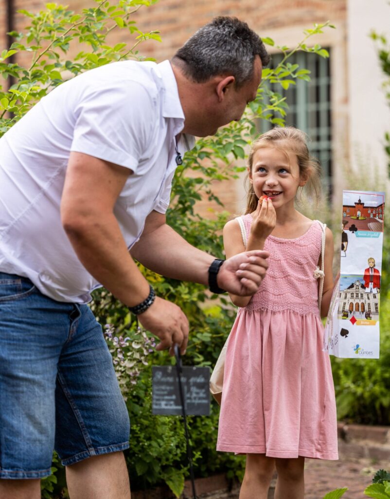 Un père et sa fille résolvant une énigme dans la cité médiévale de Châtillon-sur-Chalaronne lors d'un week-end en famille dans la Dombes